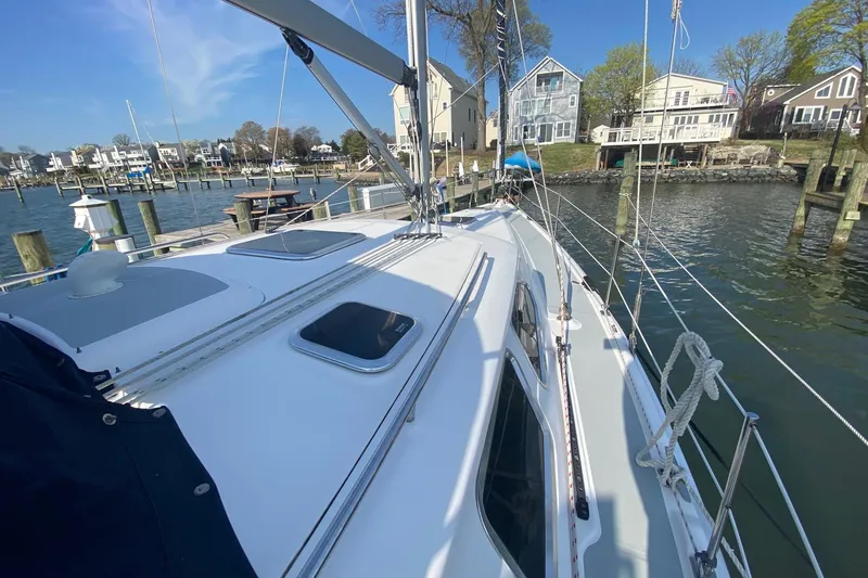 Slide: The Image of 2006 Hunter 41 Deck Salon sailboat docked in a scenic marina setting. - 33