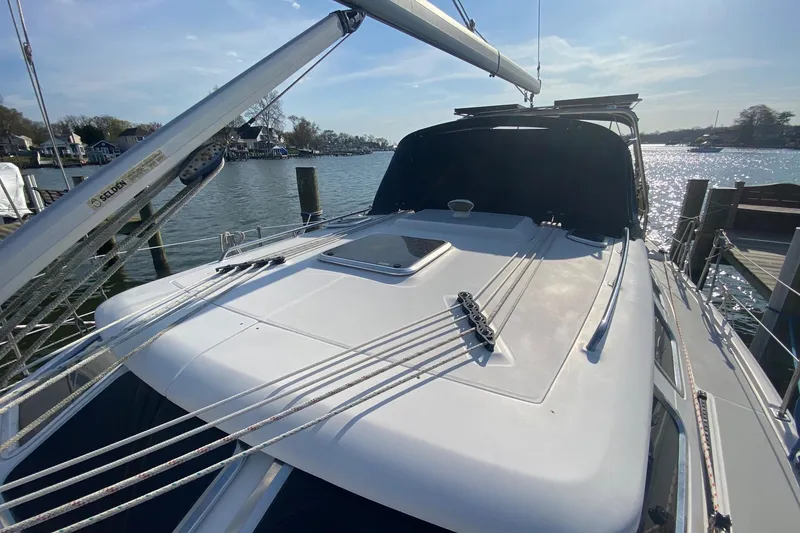 Slide: The Image of 2006 Hunter 41 Deck Salon sailboat docked, showcasing sleek deck design and rigging. - 38