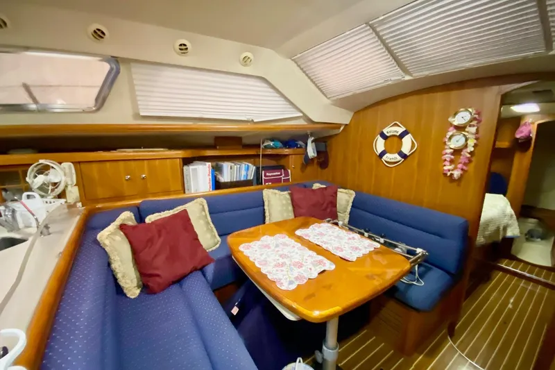 Slide: The Image of 2006 Hunter 41 Deck Salon interior with cozy seating and wooden table. - 7