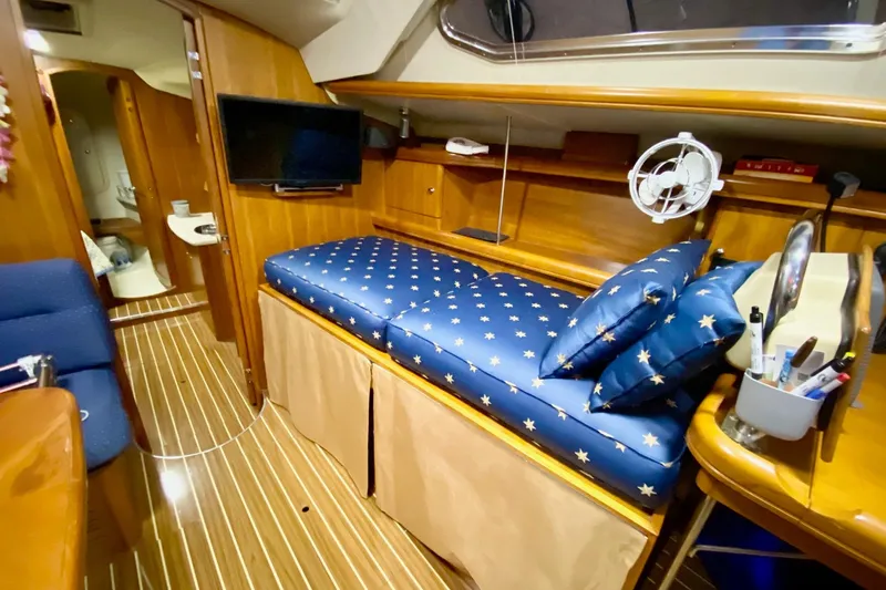 Slide: The Image of Interior of 2006 Hunter 41 Deck Salon with star-patterned cushions and wooden finishes. - 9