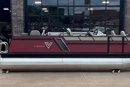 The Image of 2023 Viaggio Lago F pontoon boat with sleek maroon design, docked outdoors. - 0