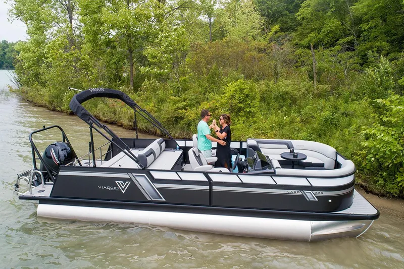 Slide: The Image of Manufacturer Provided Image: 2023 Viaggio Lago F pontoon boat on a scenic lake with lush greenery. - 9