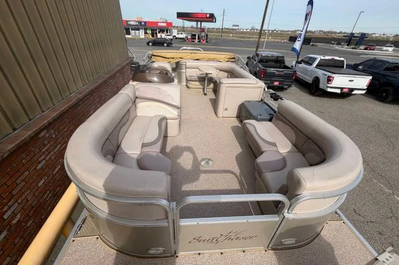 Slide: The Image of 2013 SunChaser Pontoon 22 boat with spacious seating, parked near a roadside. - 12