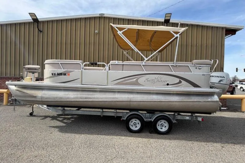 Slide: The Image of 2013 SunChaser PONTOON 22 boat on trailer, parked near a building. - 4