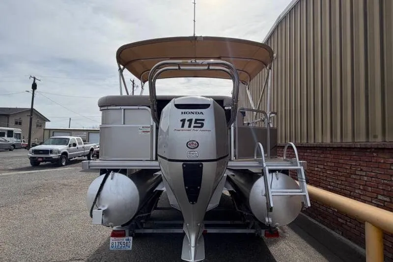 Slide: The Image of 2013 SunChaser PONTOON 22 with Honda 115 outboard motor, parked near a building. - 6