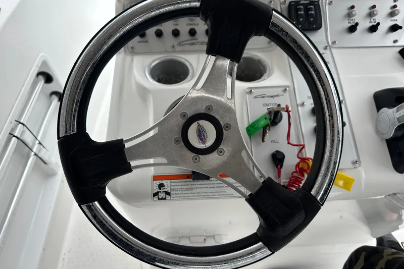 Slide: The Image of Steering wheel and controls of a 2015 Concept 27 boat cockpit. - 102