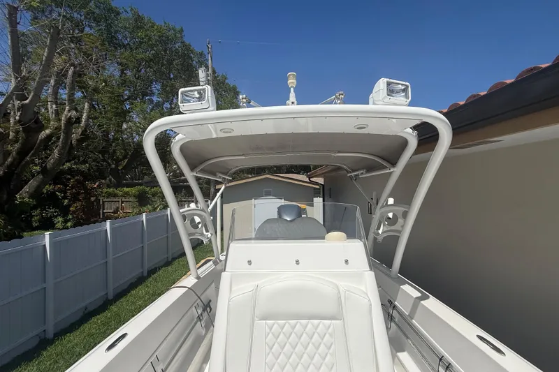 Slide: The Image of White Concept 27 boat from 2015, parked outdoors with clear blue sky. - 106