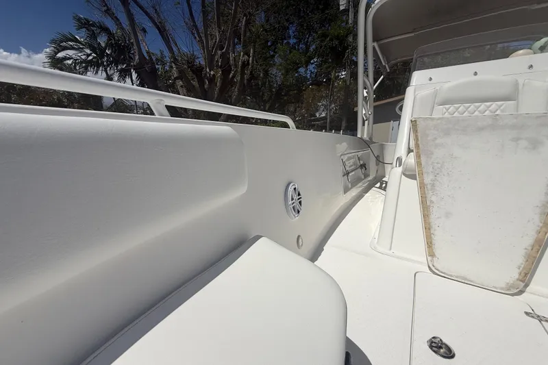 Slide: The Image of White Concept 27 boat interior, 2015 model, featuring seating and speaker, surrounded by trees. - 112