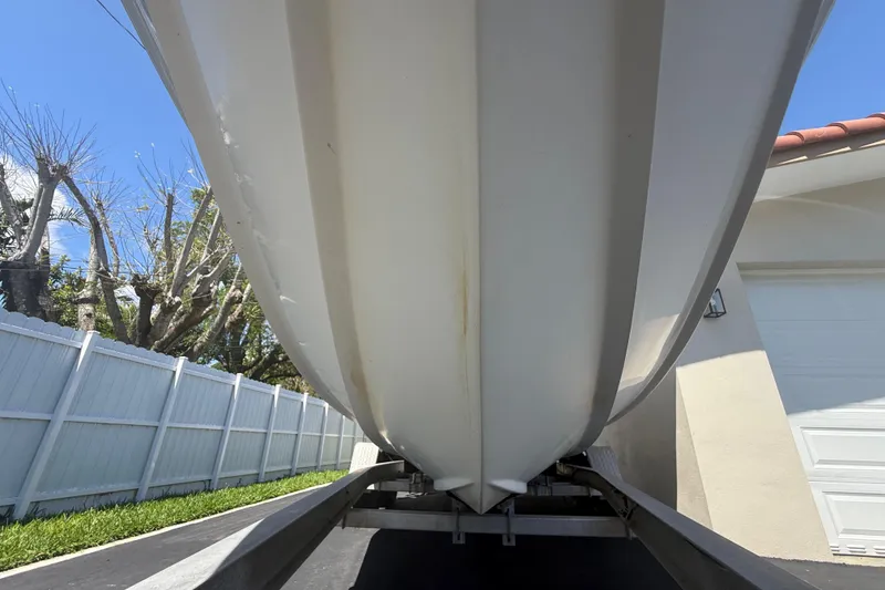 Slide: The Image of Underside view of a 2015 Concept 27 boat on a trailer, near a white fence. - 124