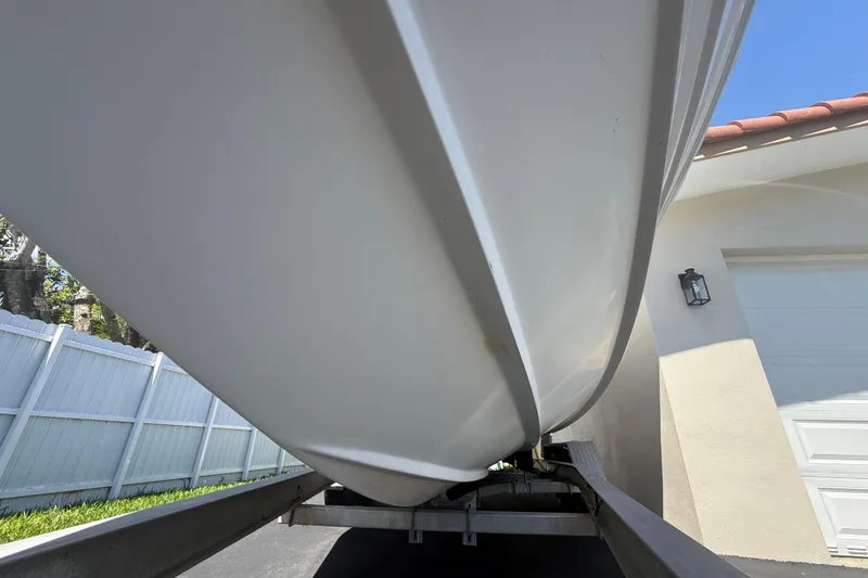 Slide: The Image of Underneath view of a 2015 Concept 27 boat on a trailer near a house. - 125