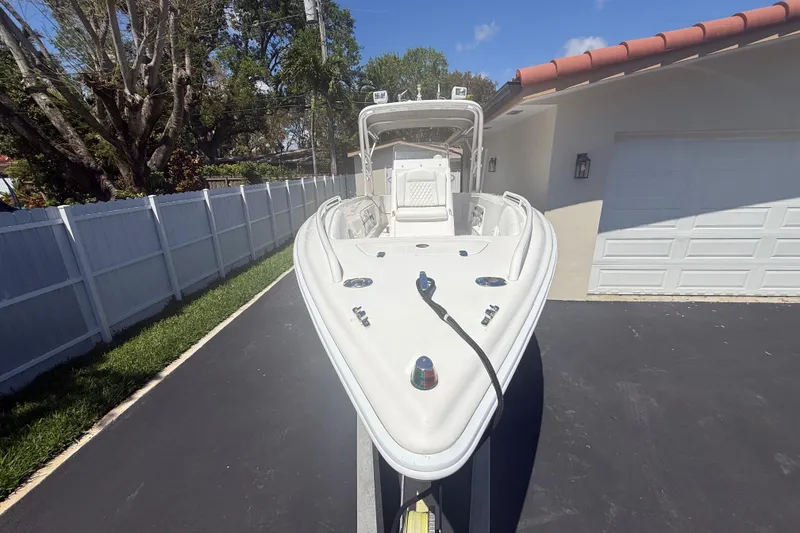 Slide: The Image of White Concept 27 boat from 2015 parked on driveway near garage. - 130