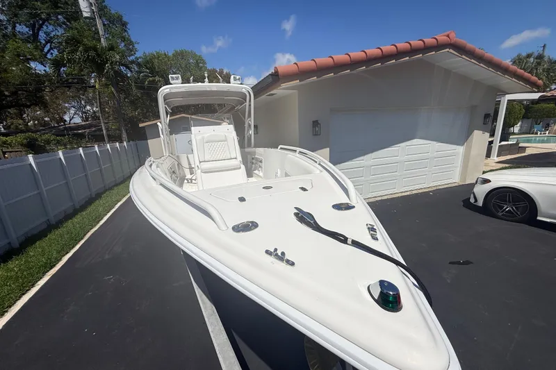 Slide: The Image of White Concept 27 boat from 2015 parked on driveway near garage. - 133