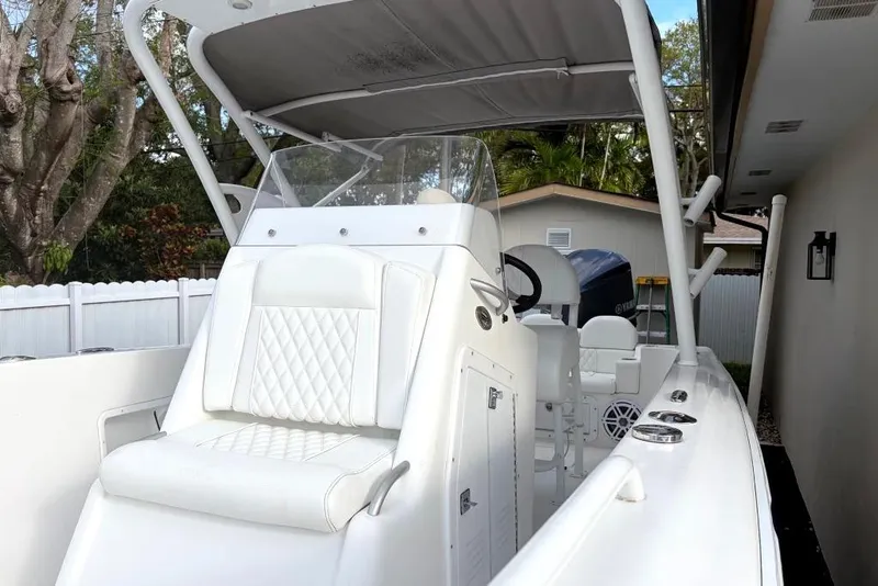 Slide: The Image of Trailer with Concept 27 boat parked on driveway, near white fence and garage, 2015 model. - 28