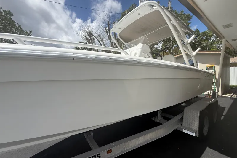 Slide: The Image of White Concept 27 boat from 2015 on a trailer, under a cloudy sky. - 34