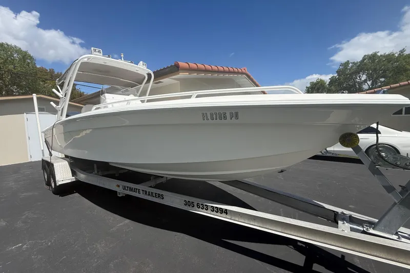 Slide: The Image of White 2015 Concept 27 boat on trailer, parked outdoors under clear blue sky. - 39