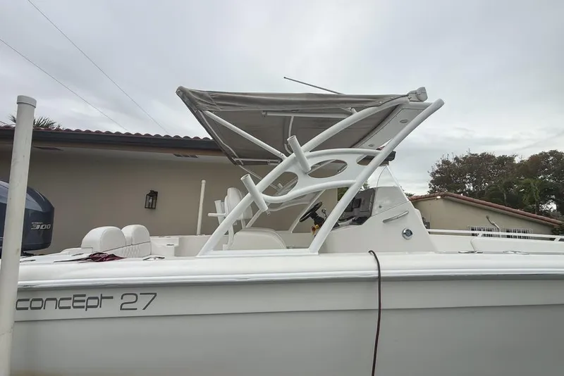 Slide: The Image of Yamaha 300 outboard motor on a Concept 27 boat, 2015 model, near a storage shed. - 73