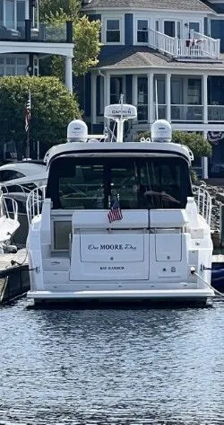 Slide: The Image of Regal 38 GC 2024 boat on calm lake with sandy shore. - 1