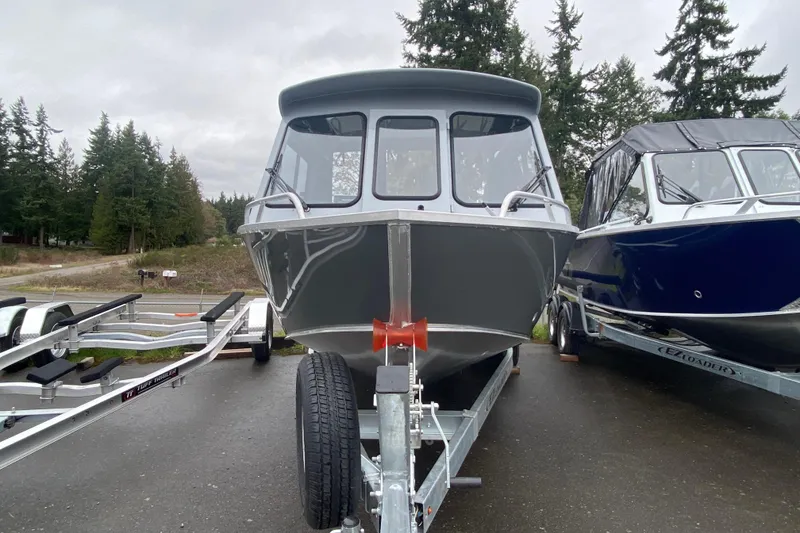 Slide: The Image of 2026 Hewescraft 200 ProV Hard Top boat on trailer, surrounded by trees. - 3