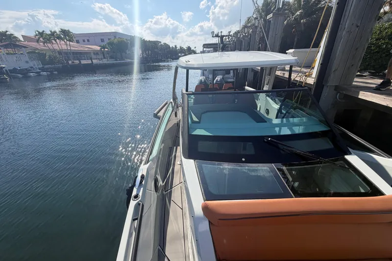 Slide: The Image of 2024 Saxdor 320 GTO docked by a sunny waterfront with palm trees. - 10