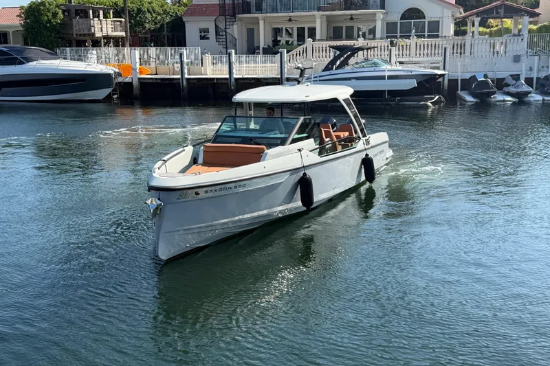 Slide: The Image of 2024 Saxdor 320 GTO boat cruising in a marina, showcasing sleek design and modern features. - 2