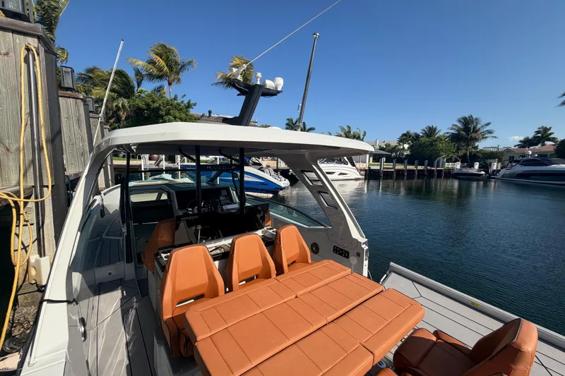 Slide: The Image of 2024 Saxdor 320 GTO boat docked, featuring sleek design and orange seating. - 23