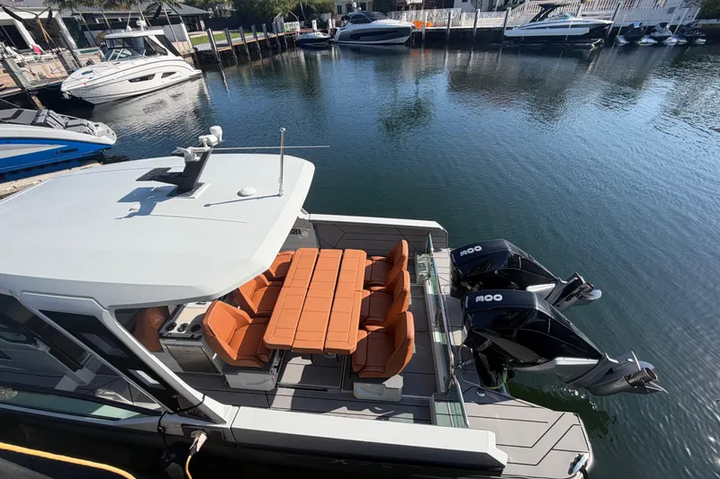 Slide: The Image of 2024 Saxdor 320 GTO boat docked, featuring twin engines and orange seating. - 24