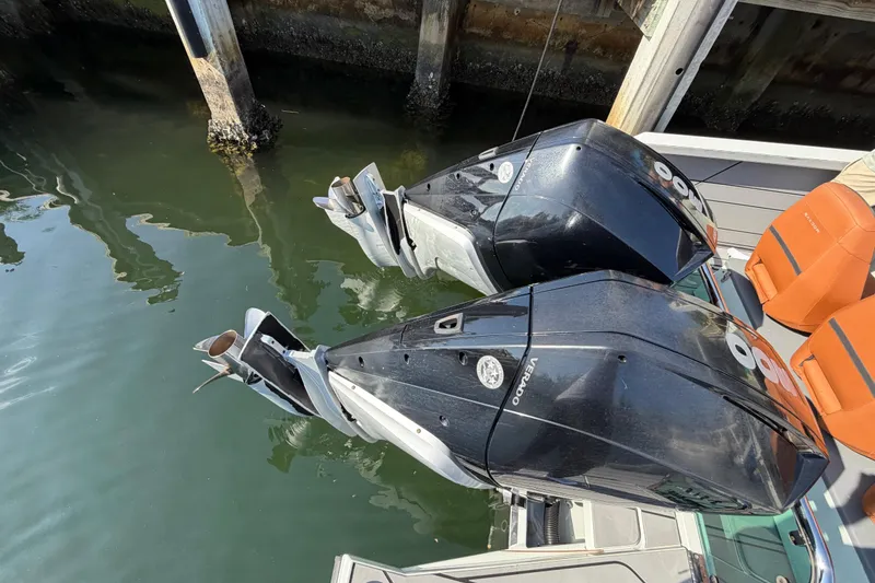 Slide: The Image of Twin outboard engines on a 2024 Saxdor 320 GTO boat docked by the water. - 28