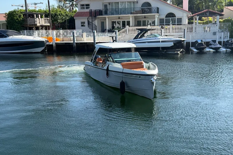Slide: The Image of 2024 Saxdor 320 GTO boat cruising in a serene waterfront setting. - 3
