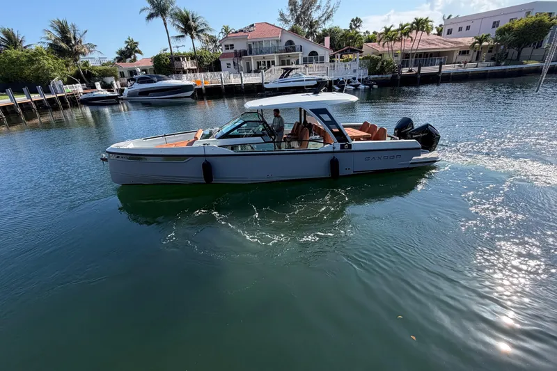Slide: The Image of 2024 Saxdor 320 GTO boat cruising in a scenic waterfront setting. - 4