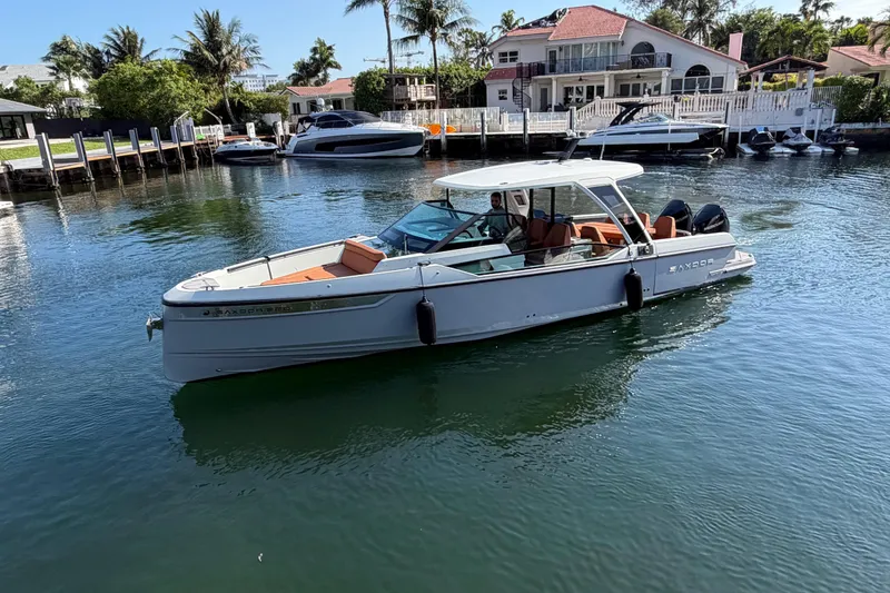 Slide: The Image of 2024 Saxdor 320 GTO boat on calm water near waterfront homes. - 6