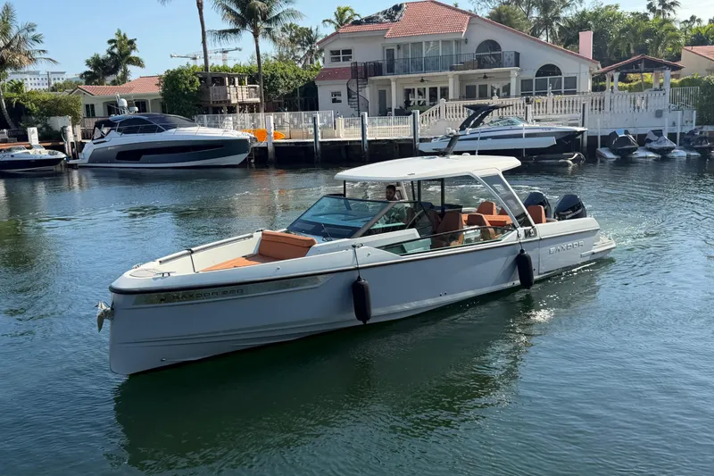 The Image of 2024 Saxdor 320 GTO boat cruising near waterfront homes and palm trees. - 0