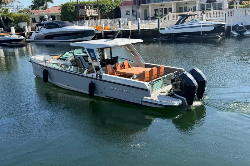 Slide: The Image of 2024 Saxdor 320 GTO boat cruising in a serene waterfront setting. - 5