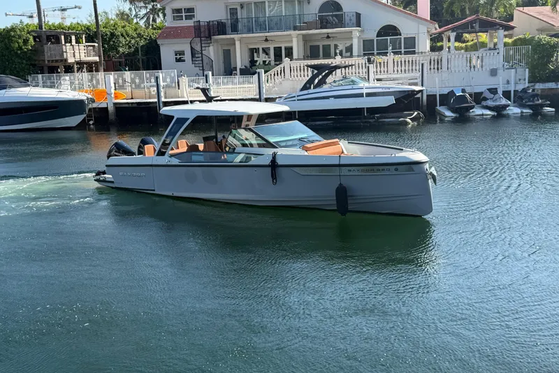 Slide: The Image of 2024 Saxdor 320 GTO boat cruising in a serene waterfront setting. - 7
