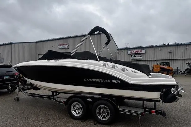 Slide: The Image of Chaparral 226 SSi 2013 boat on trailer, parked outside dealership under cloudy sky. - 2