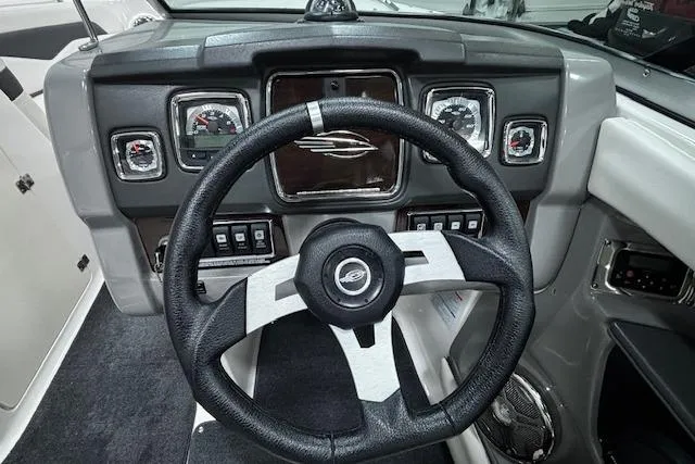 Slide: The Image of Steering wheel and dashboard of 2013 Chaparral 226 SSi boat, featuring gauges and controls. - 20