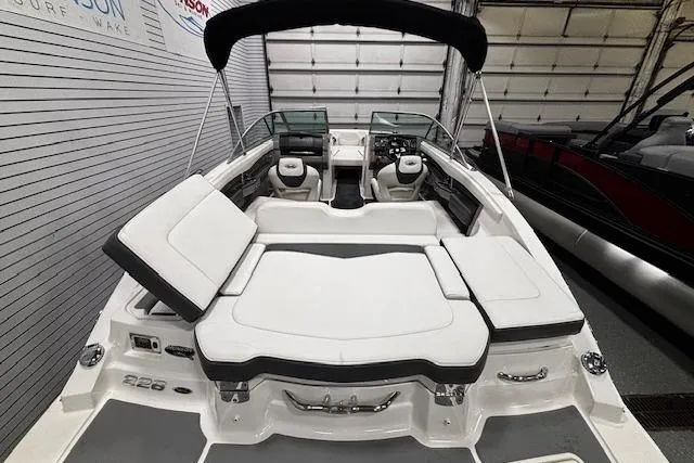 Slide: The Image of 2013 Chaparral 226 SSi boat with spacious seating and sleek design in a showroom. - 30