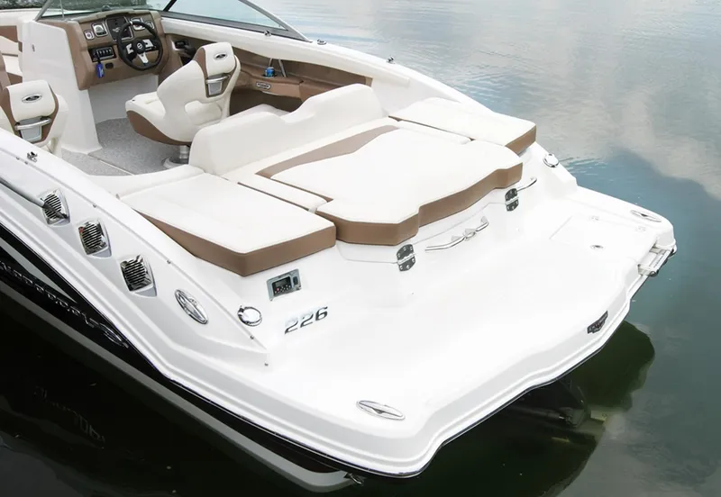 Slide: The Image of Manufacturer Provided Image: 2013 Chaparral 226 SSi boat with white and brown interior on calm water. - 8