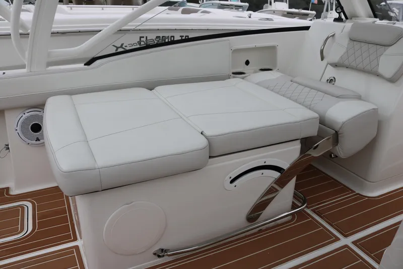 Slide: The Image of 2024 World Cat 280 DC-X boat interior with white cushioned seating and wood-patterned flooring. - 18