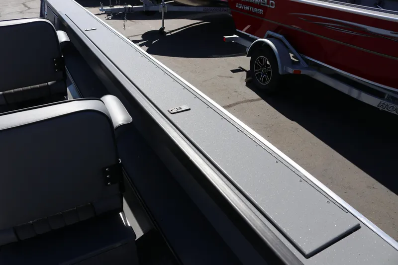 Slide: The Image of 2025 Alumaweld Columbia 23 boat interior with seating and trailer in background. - 15