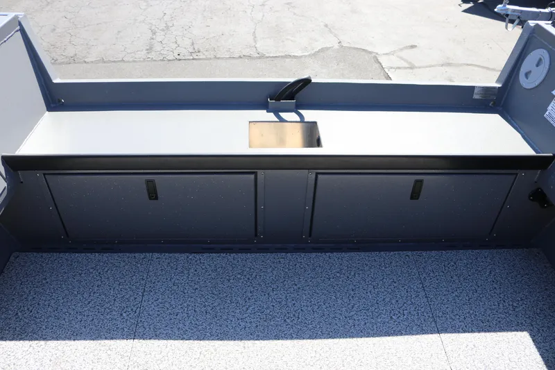 Slide: The Image of 2025 Alumaweld Columbia 23 boat interior with storage compartments and a small sink. - 21