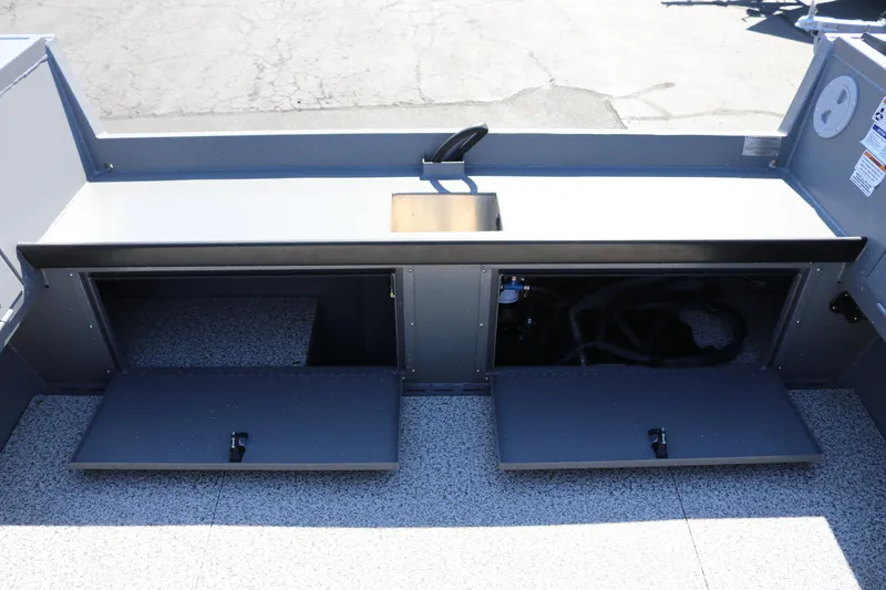 Slide: The Image of 2025 Alumaweld Columbia 23 boat interior with storage compartments and a small sink. - 23