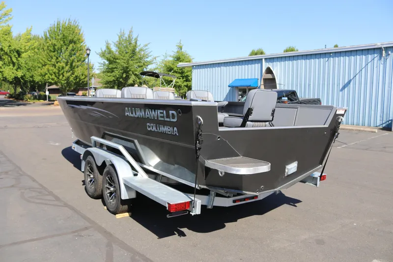 Slide: The Image of 2025 Alumaweld Columbia 23 boat on trailer, parked outdoors near blue building. - 33