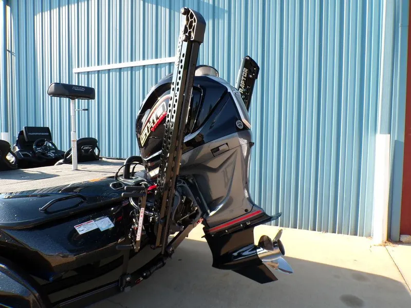 Slide: The Image of 2025 Skeeter FXR20L boat with powerful outboard motor, docked near blue corrugated wall. - 5