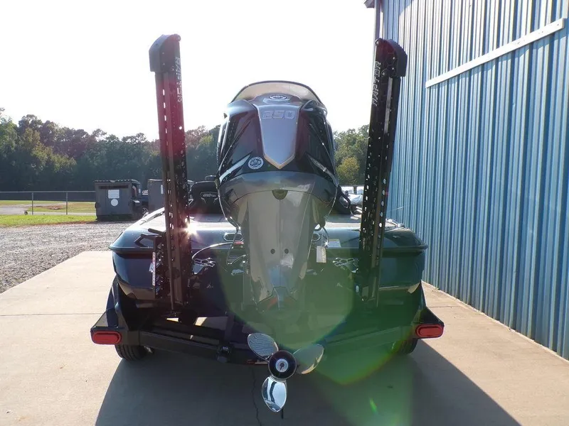 Slide: The Image of 2025 Skeeter FXR20L boat with powerful outboard motor, parked near blue building. - 6