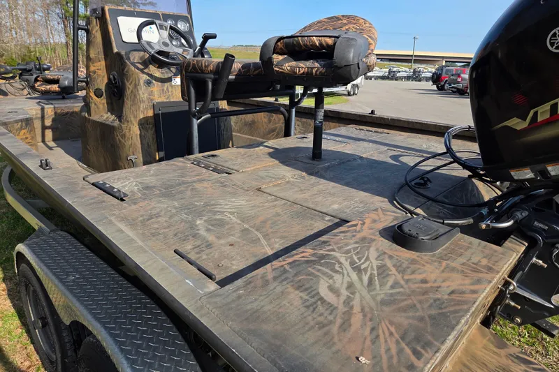 Slide: The Image of 2019 G3 Bay 20 DLX Camo boat with camouflage design and motor, parked outdoors. - 13