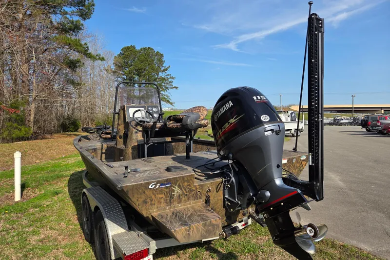 Slide: The Image of 2019 G3 Bay 20 DLX Camo boat with Yamaha motor in a parking area. - 4