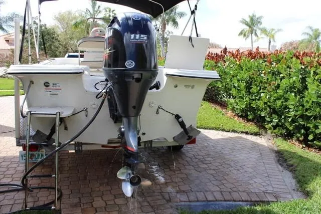 Slide: The Image of 2021 Carolina Skiff 17 LS boat with outboard motor on a sunny driveway. - 2