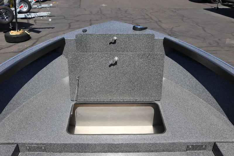 Slide: The Image of 2025 Alumaweld Free Drifter 20 boat deck with storage compartment, parked on pavement. - 12