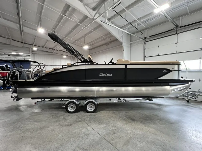 The Image of 2025 Barletta Cabrio C24UC pontoon boat in a showroom on a trailer. - 1