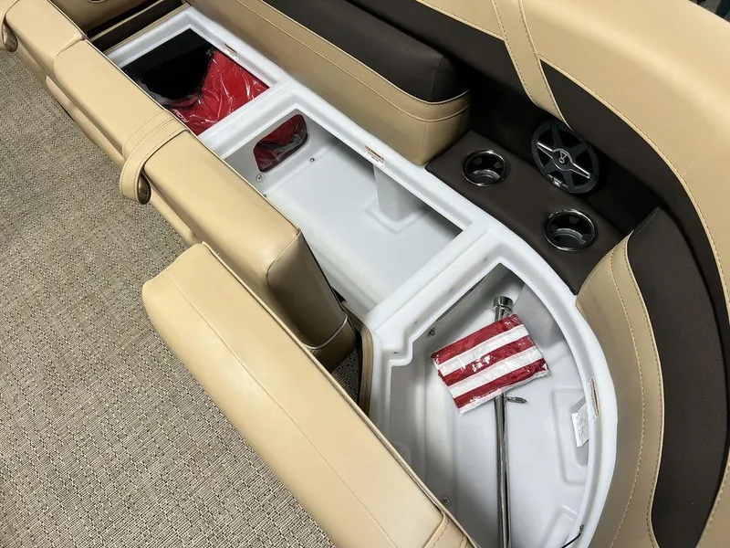 Slide: The Image of 2025 Barletta Cabrio C24UC boat interior storage compartments with beige and brown seating. - 3